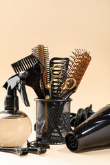 Different hairdresser's tools on beige background, closeup