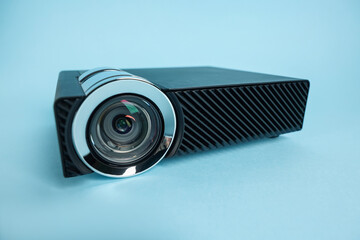 Modern video projector on light blue background, closeup