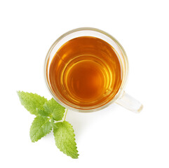 Aromatic lemon balm tea in glass cup and fresh leaves isolated on white, top view