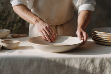skilled artisan meticulously crafting pottery in sunlit workshop surrounded by tools and raw materials