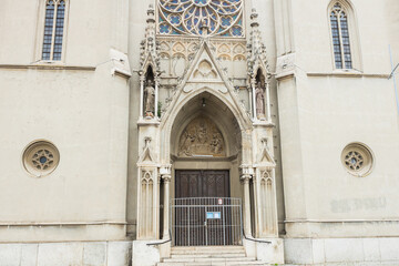 Obraz premium Close-up of a historic Gothic church main entrance, showcasing a beautifully carved tympanum sculpture above the arched doorway, Vršac, Serbia.