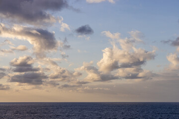 Cloudscape Over Calm Pacific Ocean with Blue Sky and Gentle Clouds at Dusk