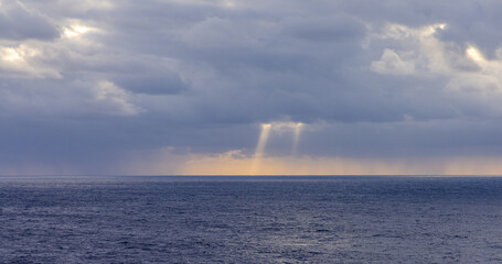 Sunlight Breaking Through Clouds Over the Tranquil Pacific Ocean