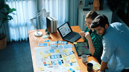 Top view of smart developer compare Ux Ui design and planning for mobile phone warframe interface development. Attractive designer programing system and brainstorming with colleague. Convocation.