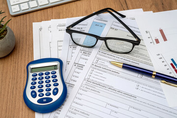Polish PIT 11 37 38 tax form prepared to be filled with pen calculator glasses on desk