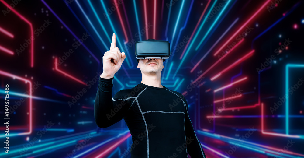 Poster professional male gamer with vr glasses pointing and playing game with glowing neon light. excited p