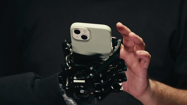 Robot Mechanical Arm Holding Green Mock-up Screen Smartphone, hand with phone AI, Industrial Robotic Manipulator End Effector Holds Mobile Phone with Chroma Key Display.