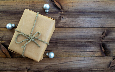 Christmas background. Gift and Christmas balls on a wooden background.