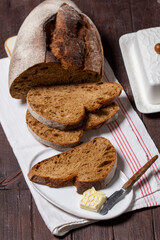 Homemade artisan bread with butter on a light background.