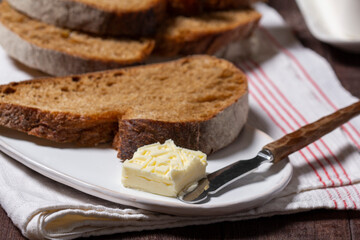 Homemade artisan bread with butter on a light background.