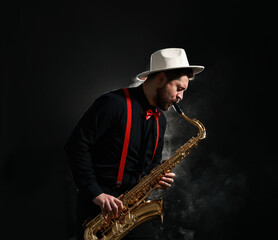 Professional musician playing saxophone on black background with smoke