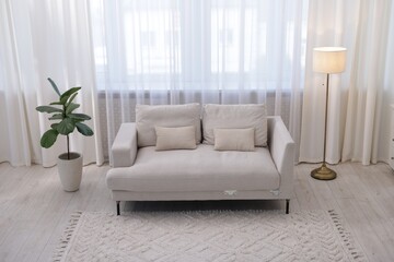 Stylish living room interior. Sofa, lamp and plant indoors