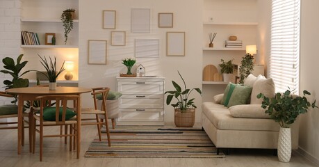 Stylish dining table with chairs and comfortable sofa in room. Interior design