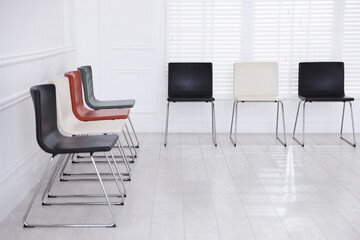 Colorful chairs near white wall in waiting room