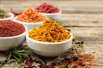 Different aromatic spices on wooden table, closeup