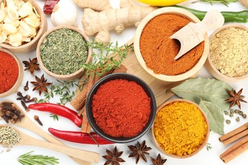 Different aromatic spices on white background, flat lay