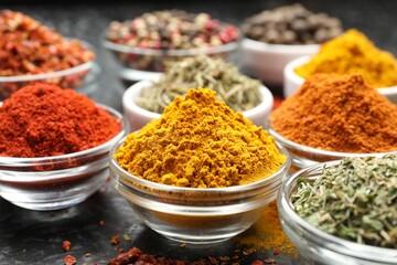 Different aromatic spices in bowls on table, closeup