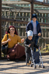 Happy young mother and her two sons playing in the park in autumn