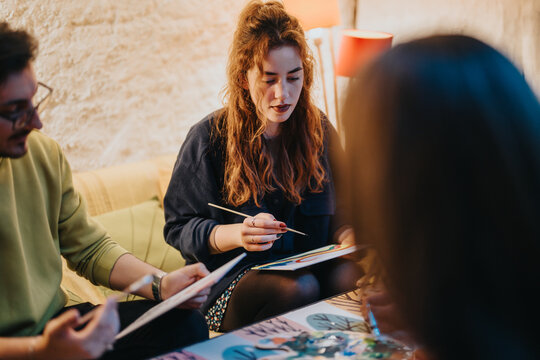 A collaborative art session where friends engage in creative painting in a warm interior.