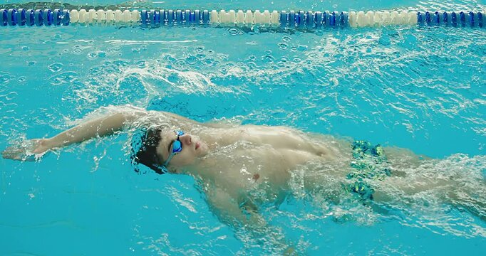 Swimmer Gliding Through the Pool. Focused and powerful strokes, clear blue water. Sports, determination and endurance. Competitions.	