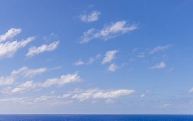 Bright Blue Sky With Clouds Overlooking a Vast Pacific Ocean Horizon