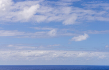 Serene Cloudscape Over a Vast Pacific Ocean Horizon Under Bright Blue Sky