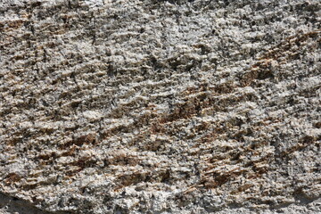 Texture of granite rough gray surface in sunlight 