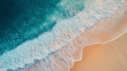Beach scene with wave crashing on sandy shore under clear blue sky during sunny day