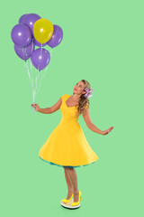 Brightly dressed woman in a yellow dress holding colorful balloons against a green background while striking a playful pose