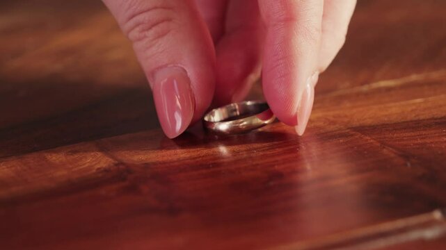 A feeling of love that fades. The woman removes wedding ring from finger. Adultery and divorce concept. High quality 4k footage