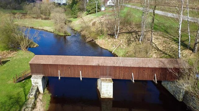 The picturesque covered wooden bridge Rechle near Lenora in the &Scaron;umava mountains &ndash; a unique national cultural monument - historic bridge with a wooden deck and stone pillars