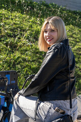 Young woman sitting on bike smiling at viewer in urban park