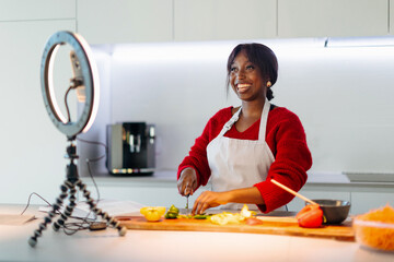 Smiling chef creating content in modern kitchen