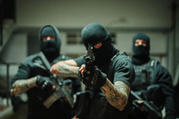 A group of fierce armed operatives displays their readiness and tactical precision, holding weapons...
