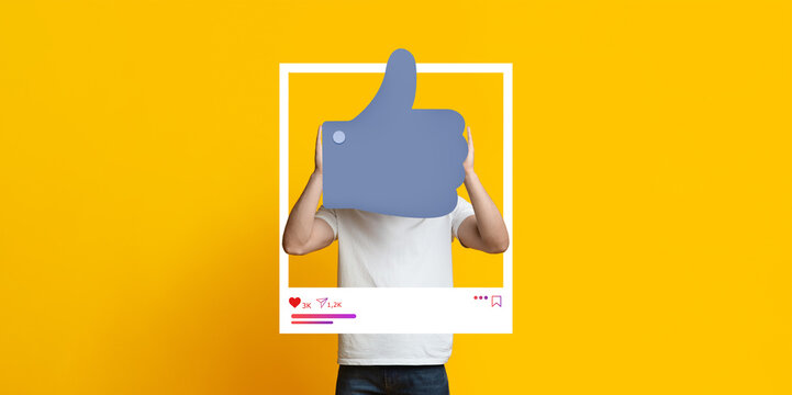 A person showcases a thumbs up gesture while posing in front of a vibrant yellow background, highlighting their support for social media engagement as a blogger or influencer.