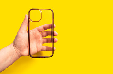 Old and dirty phone case in hand against bright yellow background, showcasing clean design and modern aesthetics, ideal for smartphone protection and style enhancement