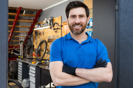 Mechanic standing with arms crossed in workshop