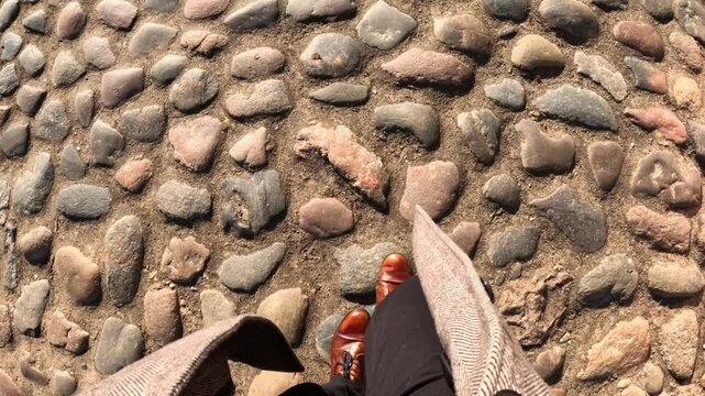 Walking the Streets: Close Up of Brown Shoes on Cobblestone Pavement