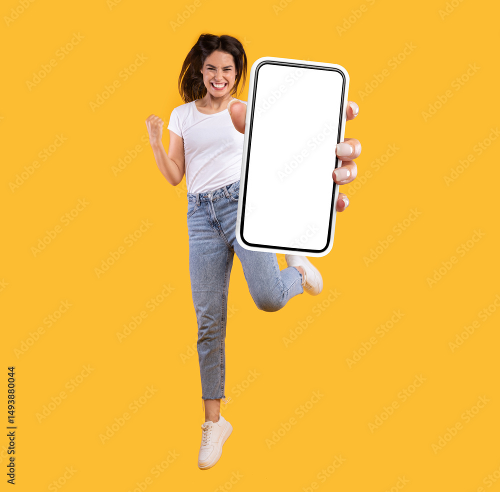 Poster yes. full body length portrait of joyful woman jumping up, making winner gesture with clenched fist 