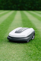 A robotic lawn mower is situated on a well-manicured grassy field, actively mowing the lawn. Modern technology and outdoor automation