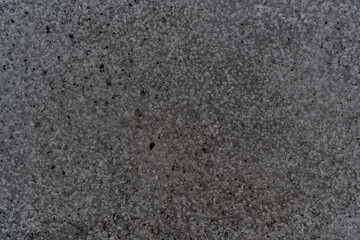 Rough concrete wall texture showing small pebbles embedded in the surface
