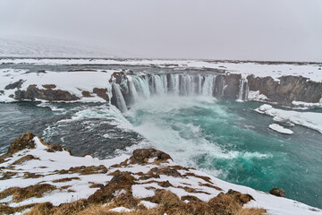 Godafoss waterfall cascading during snowfall in iceland