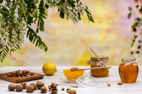 Fresh honey, lemon, nuts and acacia on a light background