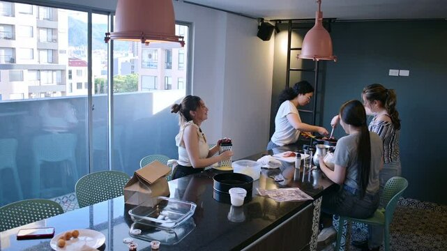Four women are engaged in baking activity, collaborating and enjoying the process of preparing food in a home kitchen setting, talking and sharing. 