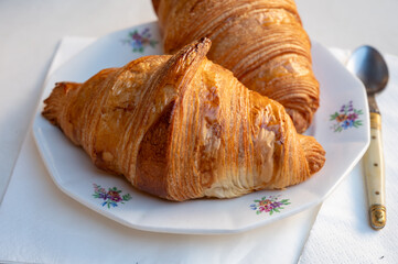 Fresh baked two buttered croissants served in restaurant for continental or French breakfast on board