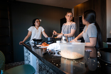 Women are in a modern kitchen talking and cooking, apartment meeting. The scene includes food preparation items.