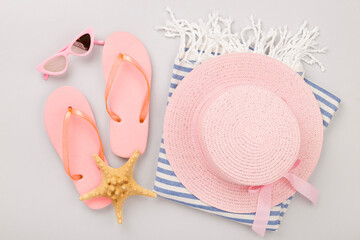 Beach towel with summer accessories on color background, top view