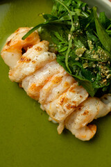 A beautifully arranged dish showcases succulent grilled prawns alongside a fresh green salad, creating a perfect culinary experience to savor at a charming restaurant