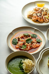 Elegant dishes arranged on pristine white plates invite diners to savor a flavorful meal. Each plate features a medley of vibrant ingredients, enhancing the dining ambiance with delicious aromas