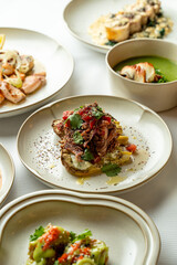 Colorful and artfully arranged dishes grace the table in a bustling restaurant, featuring a variety of flavors and textures, each promising a unique taste experience for diners